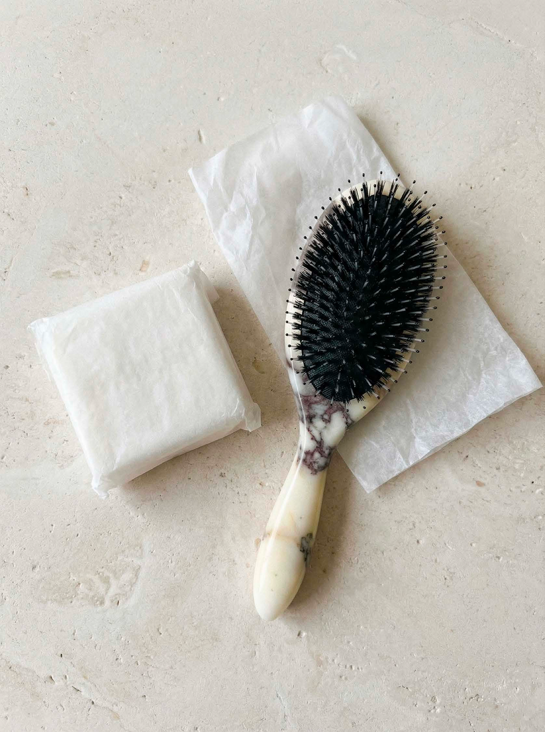 MRBL marble hair brush carved from Calacatta Viola marble with white veining, side view